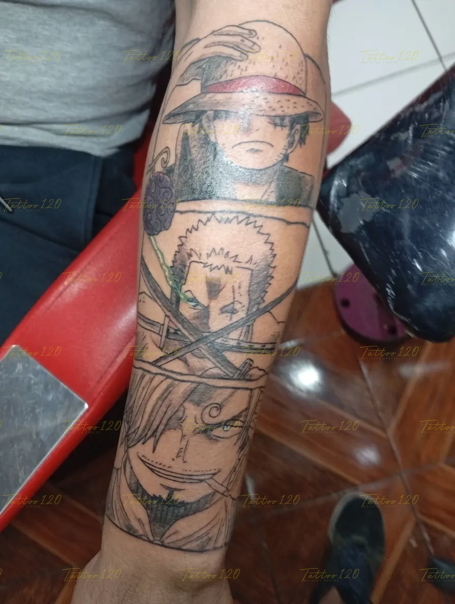 Tatuaje en el antebrazo con diseño de anime que muestra verticalmente los rostros de Luffy, Zoro con sus espadas y Sanji, personajes de One Piece en tinta negra. estilo anime, manga e ilustraciones, realizado en el estudio Tattoo120 en Colina, Región Metropolitana.