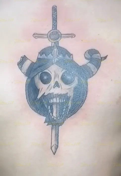 Tatuaje en la espalda o pecho que muestra una calavera con el casco con cuernos del Lich de Hora de Aventura, atravesada verticalmente por una espada. estilo anime, manga e ilustraciones, realizado en el estudio Tattoo120 en Colina, Región Metropolitana.