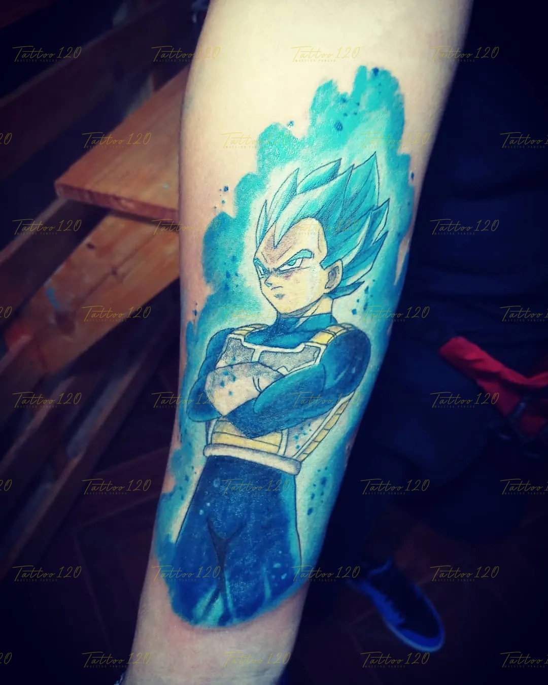 Tatuaje impactante a color de Vegeta en su transformación de Super Saiyajin Blue, envuelto en un aura de energía en tonos azul y celeste brillante. estilo anime, manga e ilustraciones, realizado en el estudio Tattoo120 en Colina, Región Metropolitana.
