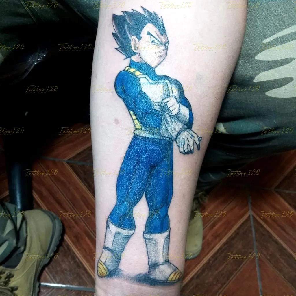Tatuaje a color en el brazo del personaje Vegeta de Dragon Ball con su armadura clásica azul y blanca, posando de brazos cruzados. estilo anime, manga e ilustraciones, realizado en el estudio Tattoo120 en Colina, Región Metropolitana.