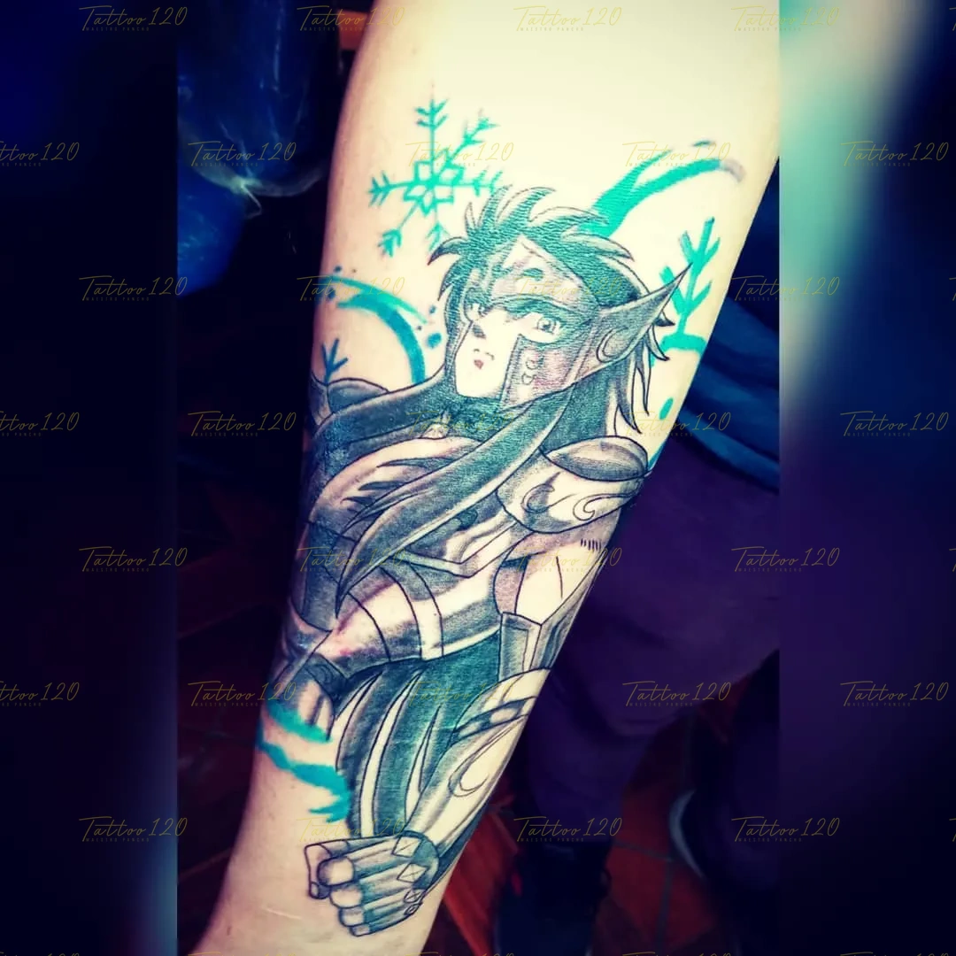 Tatuaje en el brazo del caballero Hyoga de Cisne de Los Caballeros del Zodíaco, realizado con sombreados negros y vivos detalles celestes junto a un copo de nieve. estilo anime, manga e ilustraciones, realizado en el estudio Tattoo120 en Colina, Región Metropolitana.
