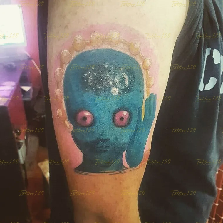 Tatuaje a color inspirado en la película de animación Planeta Salvaje, mostrando el rostro de un ser alienígena azul con ojos rosados y detalles espaciales. estilo anime, manga e ilustraciones, realizado en el estudio Tattoo120 en Colina, Región Metropolitana.