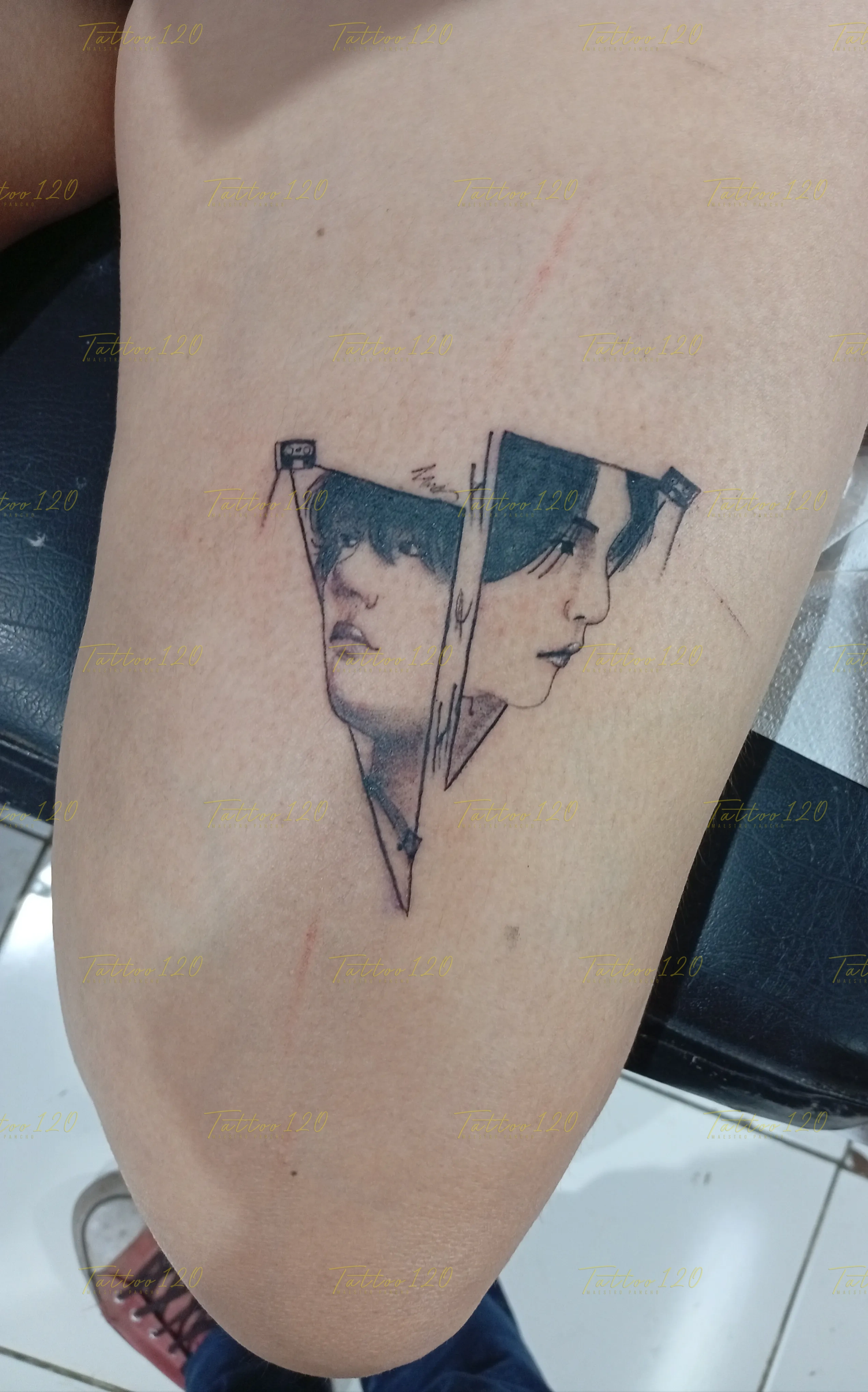 Tatuaje de dos retratos masculinos de perfil inscritos dentro de formas triangulares con sutiles sombreados, en estilo de línea fina y minimalistas, realizado en el estudio Tattoo120 en Colina, Región Metropolitana.