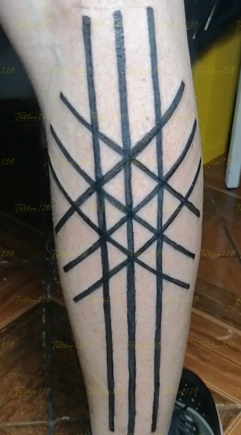 Tatuaje en la pierna de patrón lineal abstracto con gruesas líneas negras que se cruzan formando una red geométrica rúnica, en estilo de polinesios y tribales, realizado en el estudio Tattoo120 en Colina, Región Metropolitana.