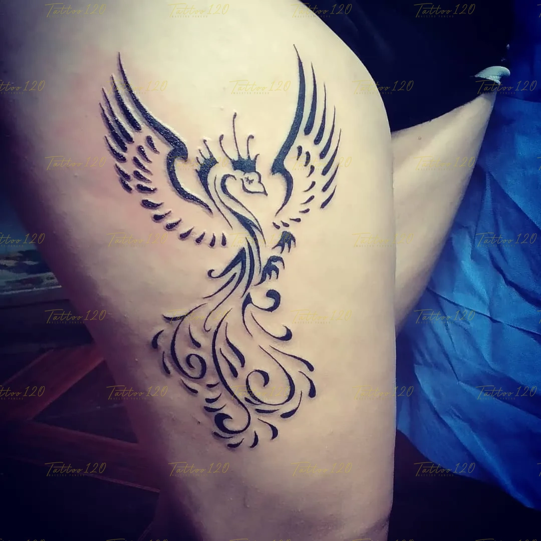 Tatuaje en el muslo de la silueta de un ave fénix con las alas extendidas diseñada a partir de trazos tribales limpios, en estilo de polinesios y tribales, realizado en el estudio Tattoo120 en Colina, Región Metropolitana.