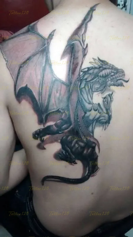 Tatuaje en la espalda de un dragón mitológico con las alas abiertas y rabo extendido, trabajado con contrastes y sombras suaves, en estilo de realistas, retratos y sombras, realizado en el estudio Tattoo120 en Colina, Región Metropolitana.