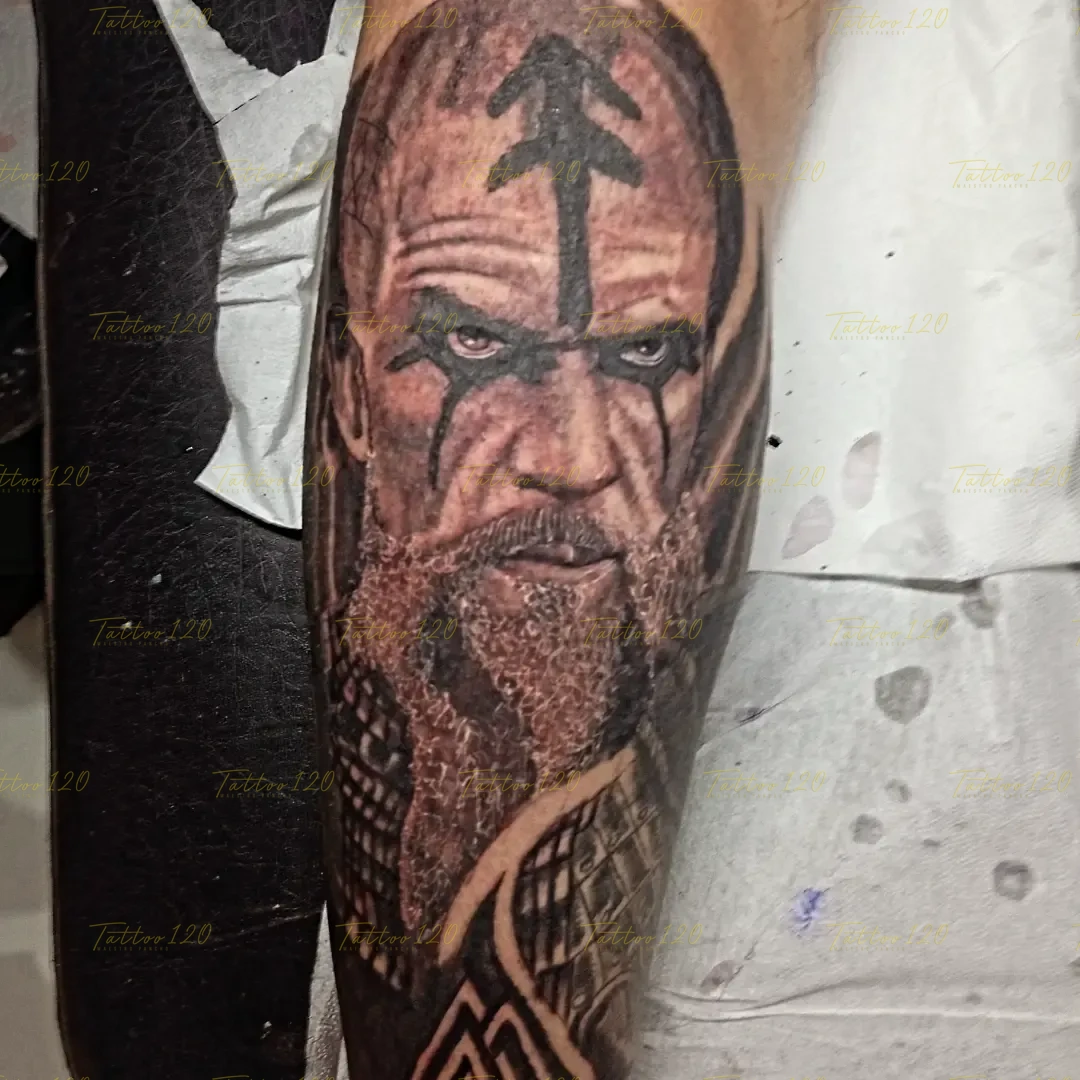 Tatuaje realista de un guerrero vikingo con barba trenzada y marcas rúnicas pintadas en la frente, en estilo de realistas, retratos y sombras, realizado en el estudio Tattoo120 en Colina, Región Metropolitana.