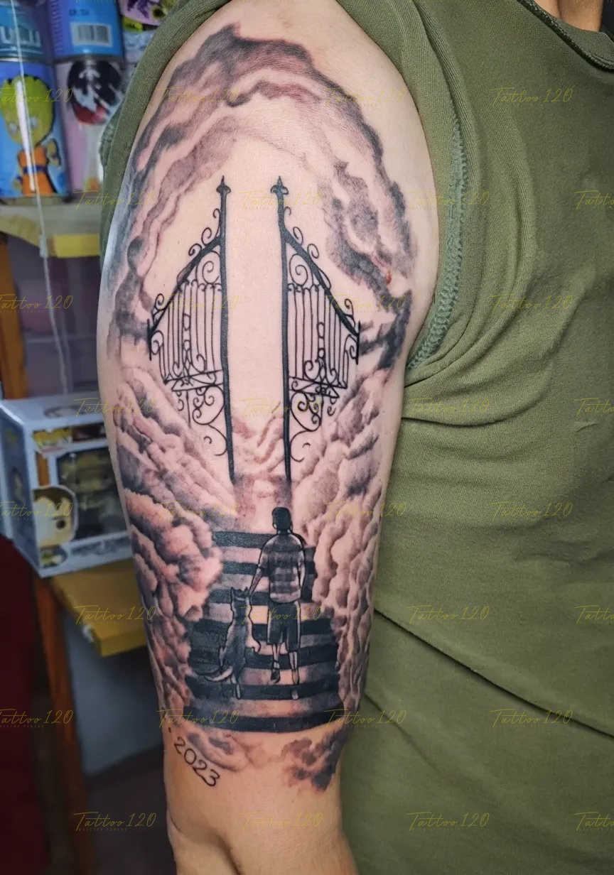 Tatuaje conmemorativo que muestra a una persona caminando con su perro hacia las puertas del cielo entre nubes y el año 2023, en estilo de realistas, retratos y sombras, realizado en el estudio Tattoo120 en Colina, Región Metropolitana.