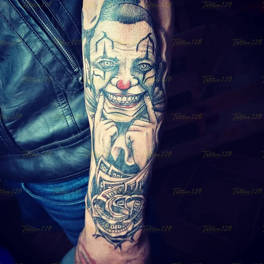 Tatuaje detallado en el brazo que muestra a un payaso de sonrisa malévola sosteniendo sus mejillas sobre una rosa hecha de billetes de dólares, en estilo de realistas, retratos y sombras, realizado en el estudio Tattoo120 en Colina, Región Metropolitana.