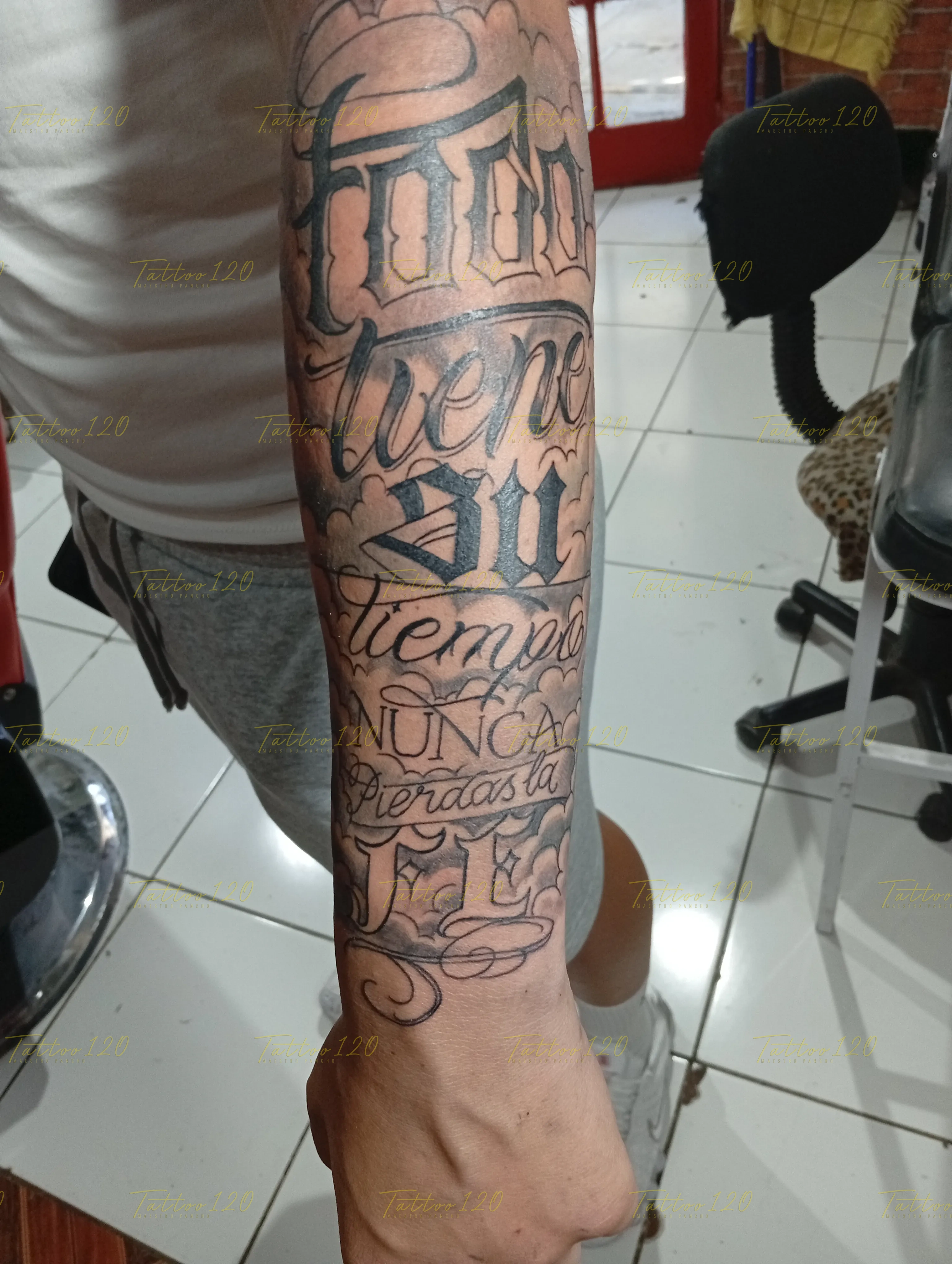 Tatuaje de letras, nombres y frases en caligrafía chicana sobre el brazo y antebrazo, estilo de letras, frases y chicano, realizado en el estudio Tattoo120 en Colina, Región Metropolitana.