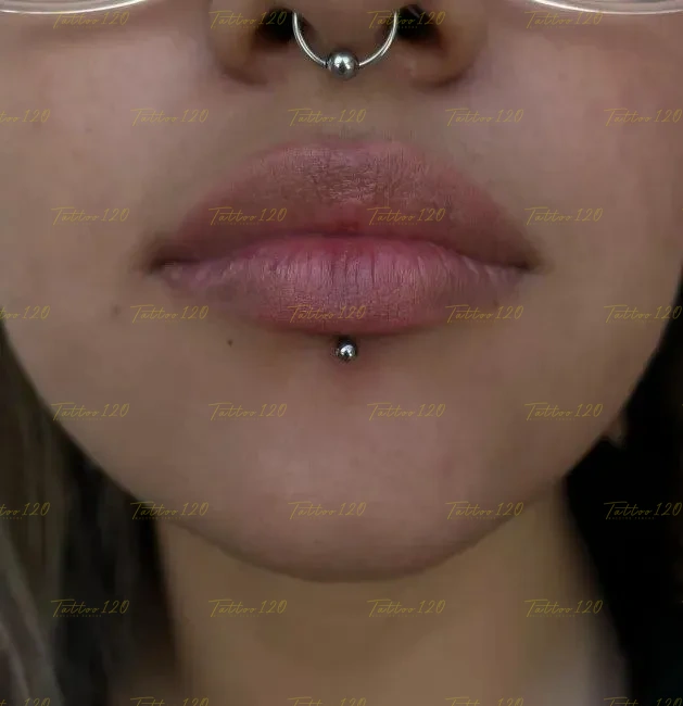 Perforaciones faciales que muestran piercing Labret en el labio y Septum en la nariz, realizado en el estudio Tattoo120 en Colina, Región Metropolitana.