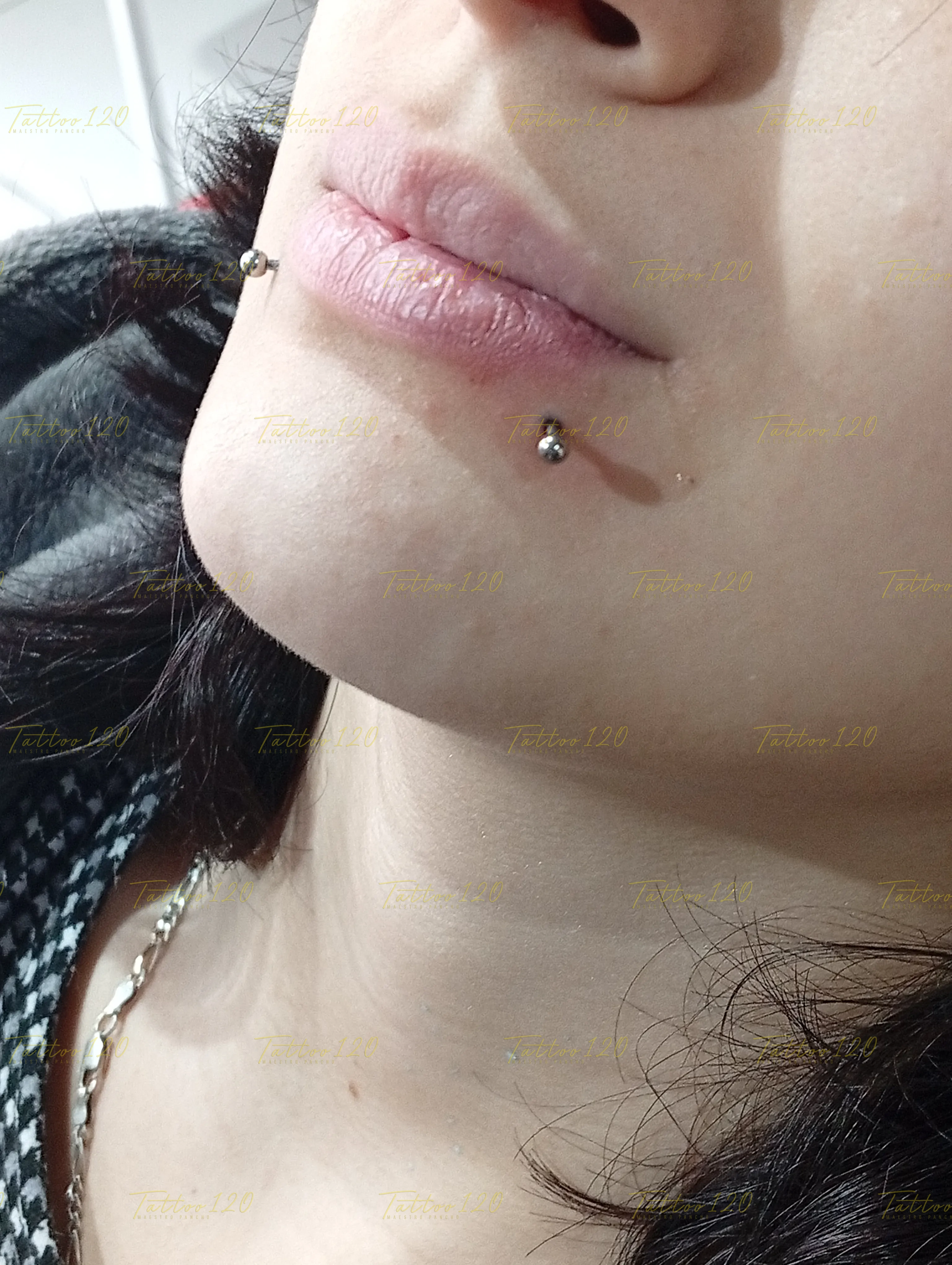 Perforación de piercing Snake Bites doble en el labio inferior con joyería de titanio, realizado en el estudio Tattoo120 en Colina, Región Metropolitana.